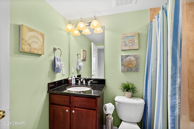 bathroom featuring vanity, toilet, and walk in shower