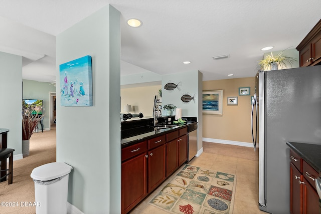 kitchen featuring sink, stainless steel appliances, dark stone counters, and light tile patterned flooring