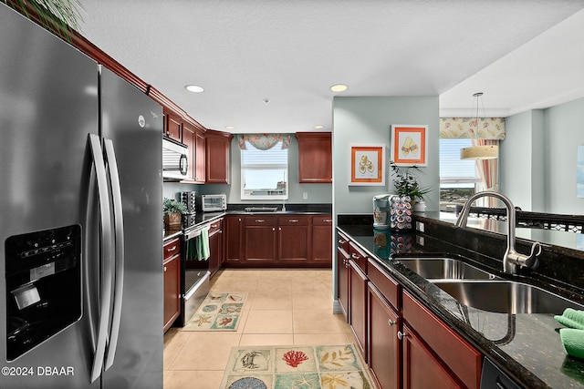 kitchen with hanging light fixtures, appliances with stainless steel finishes, a wealth of natural light, and sink