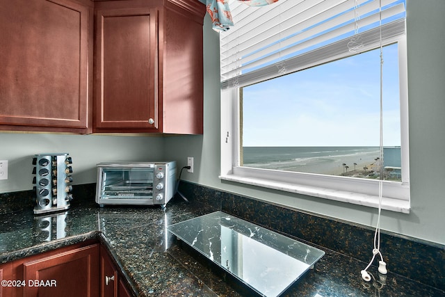 interior space featuring a water view and dark stone counters