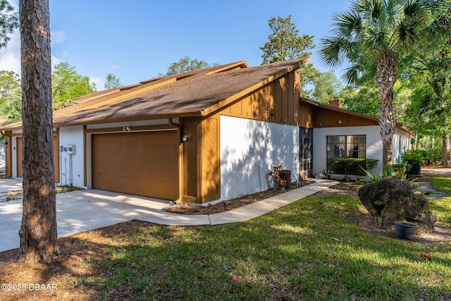 view of front facade featuring a garage, a front yard, driveway, and a chimney