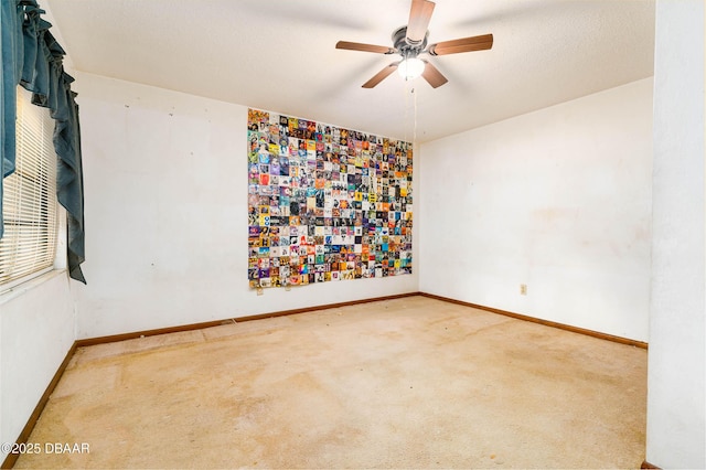 carpeted empty room with baseboards and ceiling fan