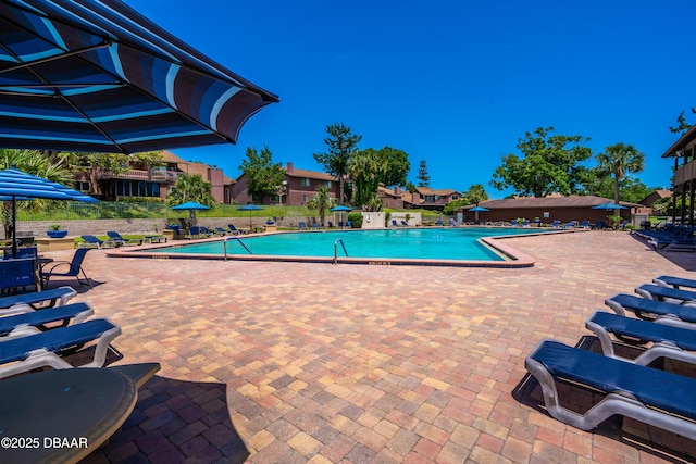 community pool with a patio and fence