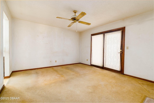 empty room featuring baseboards, a ceiling fan, and light carpet
