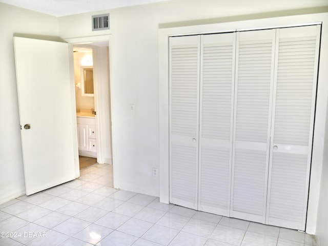 1508 Virginia Ave Unit 103, Daytona Beach, FL 32114 - unfurnished bedroom featuring a closet, light tile patterned floors, and a sink