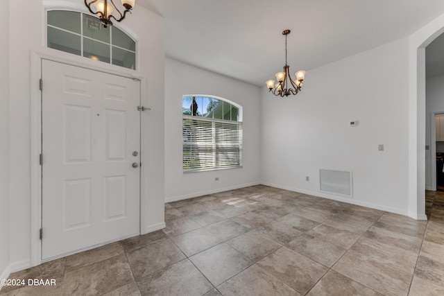 tiled foyer entrance featuring a notable chandelier