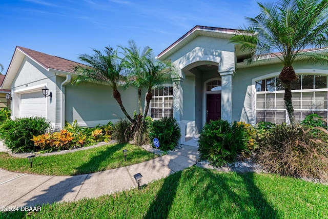 view of front facade with a garage and a front lawn