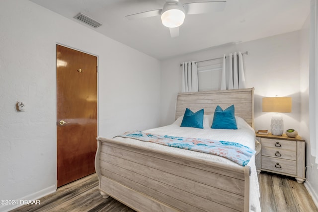 bedroom with dark hardwood / wood-style flooring and ceiling fan