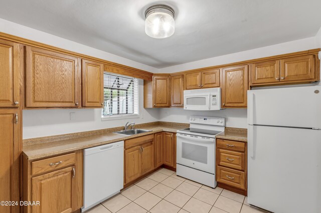 kitchen with white appliances, sink, and light tile patterned flooring