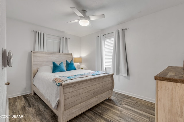 bedroom with dark hardwood / wood-style flooring and ceiling fan