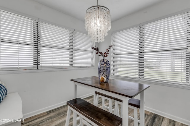 dining area featuring wood-type flooring and a chandelier