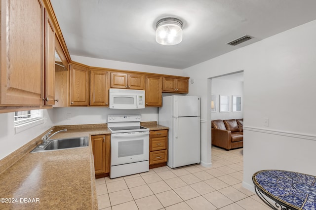 kitchen with a wealth of natural light, sink, white appliances, and light tile patterned flooring