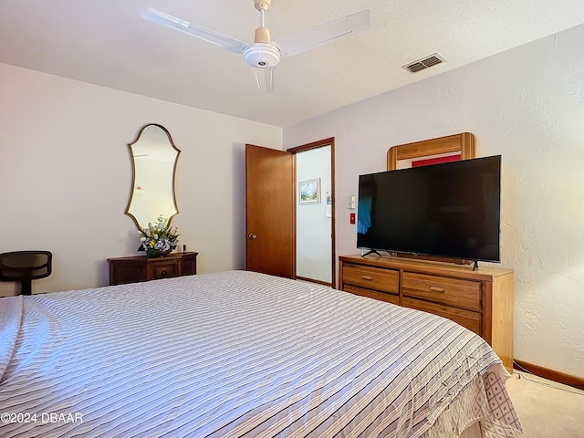 carpeted bedroom featuring a textured ceiling and ceiling fan