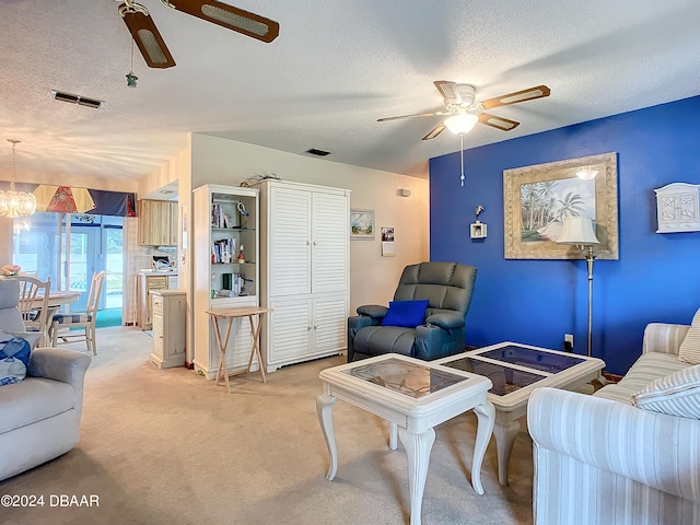 carpeted living room featuring ceiling fan with notable chandelier and a textured ceiling