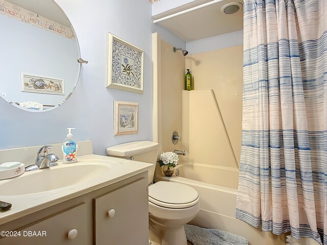 full bathroom featuring shower / bath combo with shower curtain, vanity, and toilet