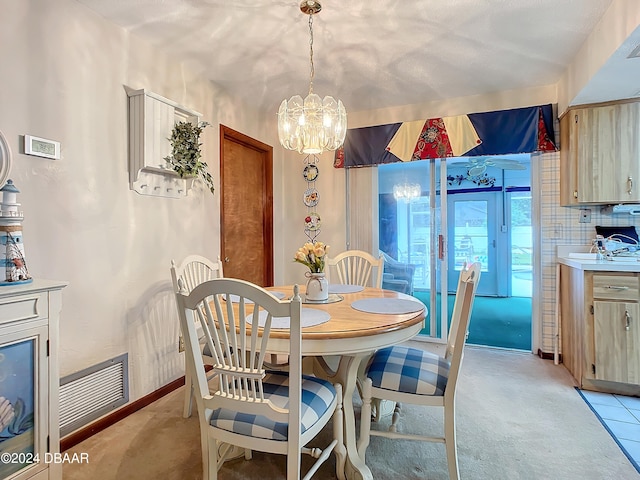 dining room featuring a notable chandelier and light carpet