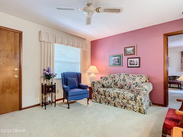 living room featuring a textured ceiling, light colored carpet, and ceiling fan