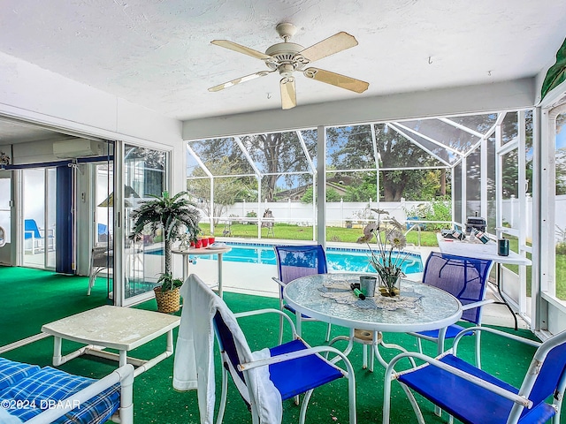 sunroom featuring a wall mounted AC and ceiling fan