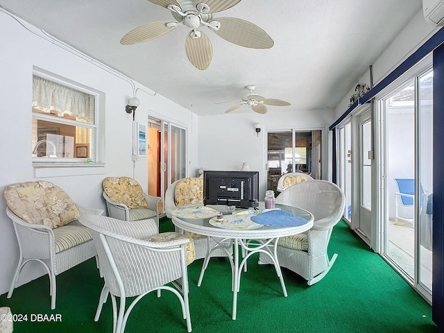 sunroom / solarium featuring a wall unit AC and ceiling fan