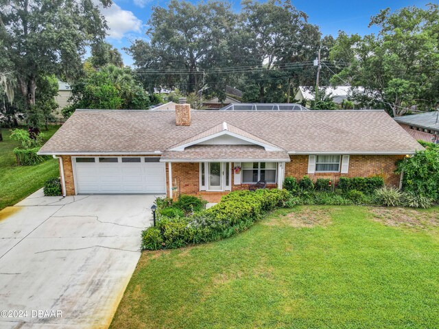 ranch-style home featuring a front lawn and a garage