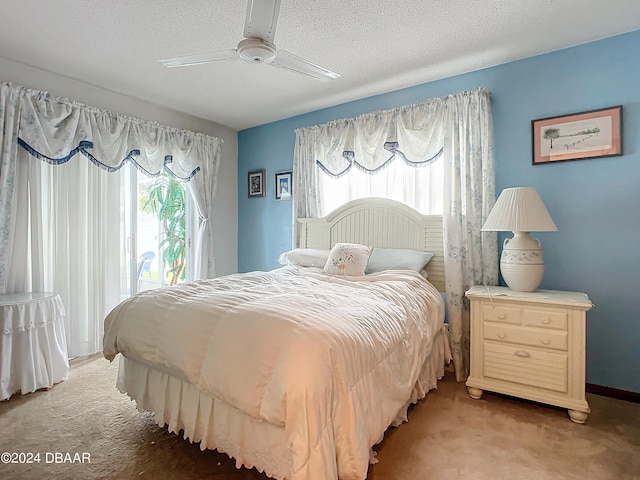 carpeted bedroom featuring multiple windows, a textured ceiling, and ceiling fan