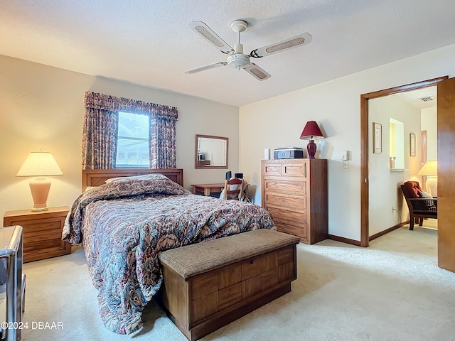 carpeted bedroom featuring ceiling fan and a textured ceiling