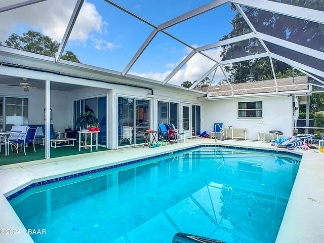 view of pool with ceiling fan, a patio, and a lanai