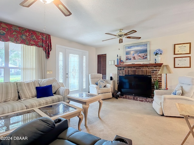 carpeted living room with a brick fireplace, a textured ceiling, and ceiling fan