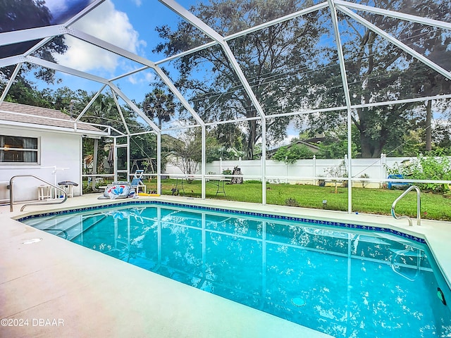 view of swimming pool with a patio, glass enclosure, and a lawn