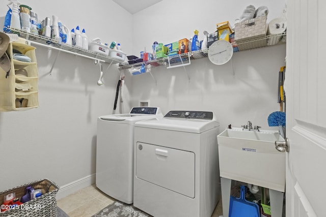 clothes washing area with washing machine and dryer, sink, and light tile patterned flooring