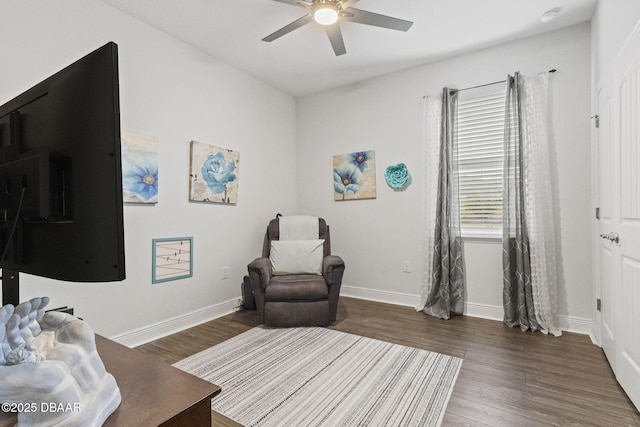 living area featuring dark hardwood / wood-style flooring and ceiling fan