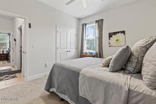 bedroom with light carpet, a closet, and ceiling fan