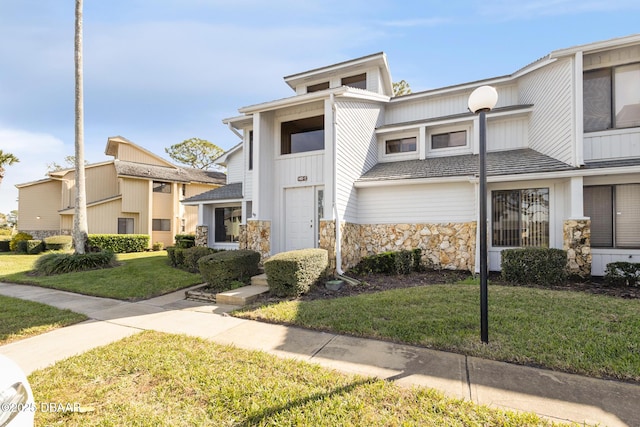 townhome / multi-family property with a front yard