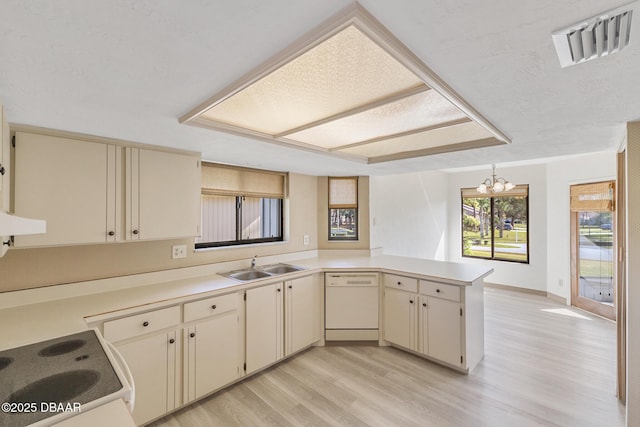 kitchen featuring sink, hanging light fixtures, white dishwasher, kitchen peninsula, and stove