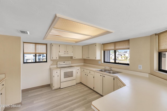 kitchen with sink, white electric range, a textured ceiling, cream cabinetry, and light wood-type flooring