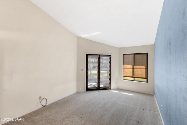 empty room featuring lofted ceiling and light carpet