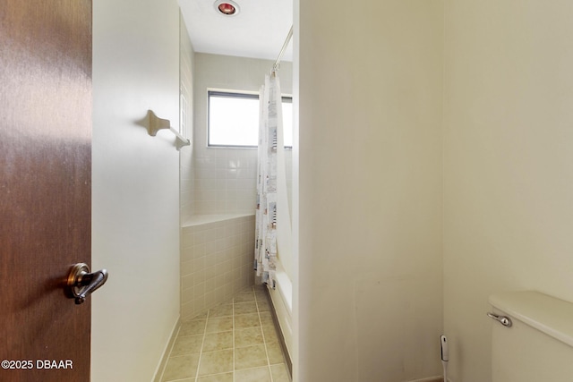 bathroom with tile patterned flooring, shower / bathtub combination with curtain, and toilet