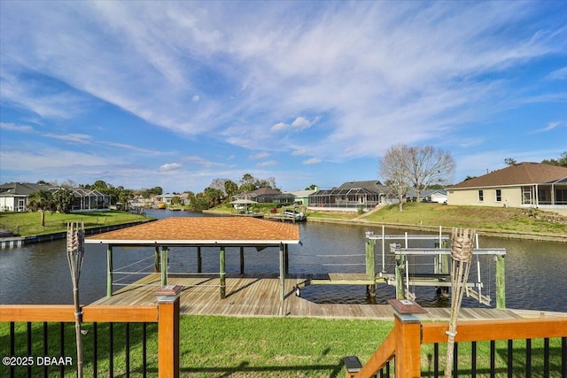 dock area featuring a water view, boat lift, a residential view, and a yard