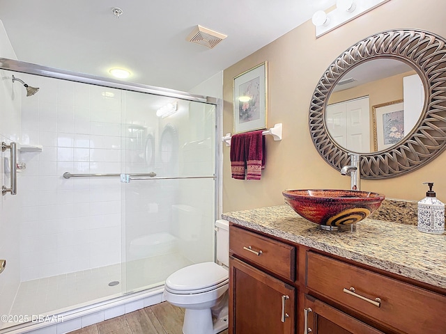 bathroom featuring toilet, an enclosed shower, and vanity