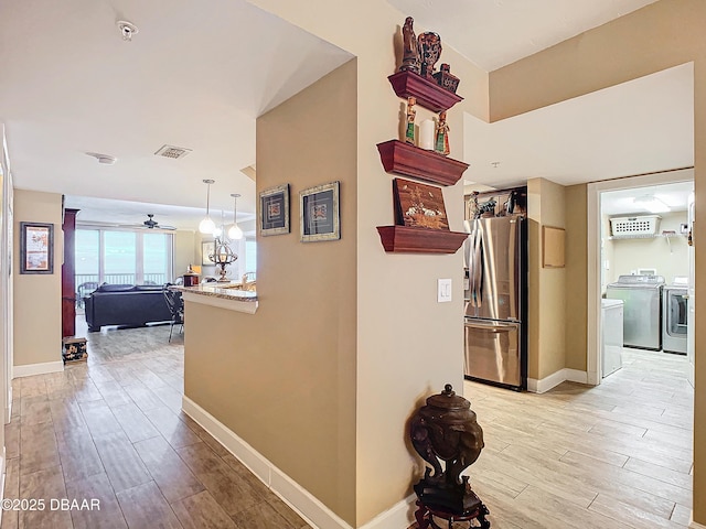 hallway featuring washing machine and dryer and light hardwood / wood-style floors