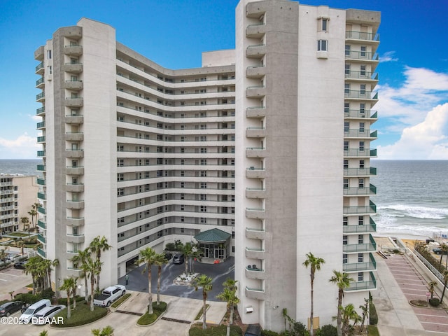 view of building exterior featuring a beach view and a water view