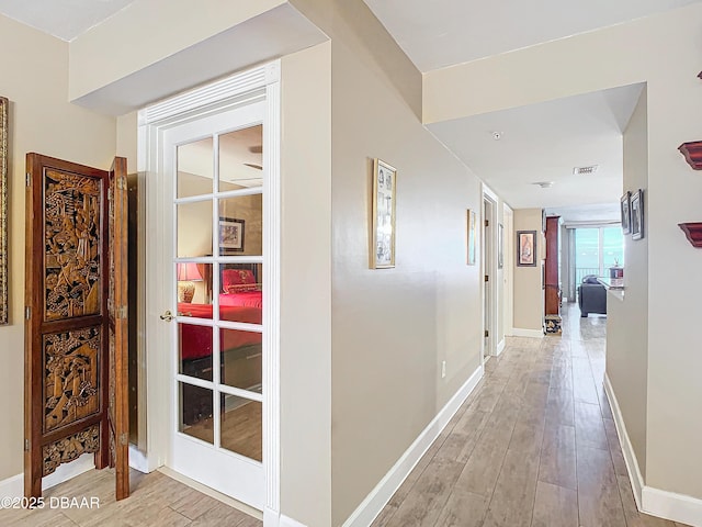 corridor with light hardwood / wood-style flooring