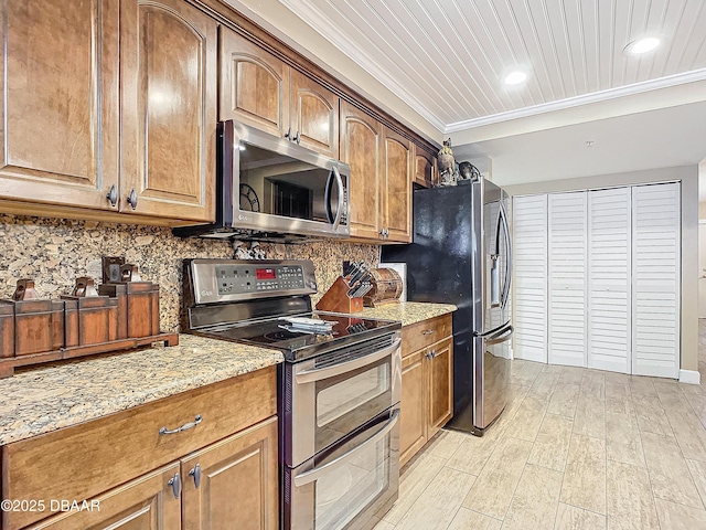 kitchen featuring decorative backsplash, light stone counters, crown molding, and appliances with stainless steel finishes