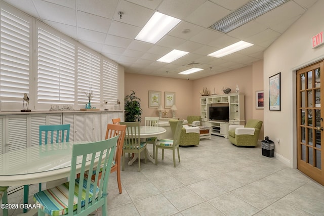 living room with light tile patterned floors and a drop ceiling