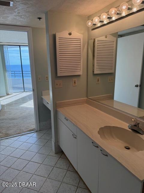 bathroom with a textured ceiling, vanity, and tile patterned flooring