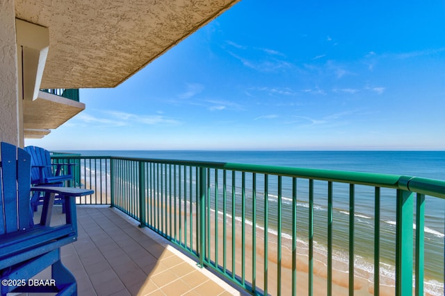 balcony with a water view and a beach view