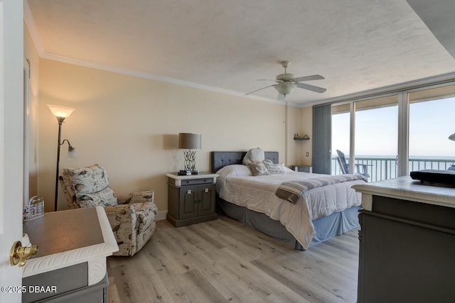 bedroom featuring ornamental molding, access to outside, ceiling fan, light hardwood / wood-style floors, and a water view