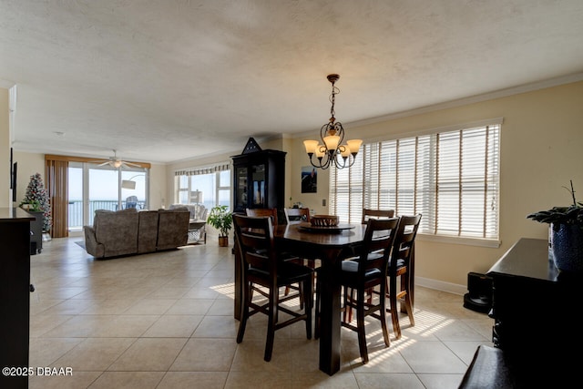 tiled dining space with crown molding, ceiling fan with notable chandelier, and a textured ceiling