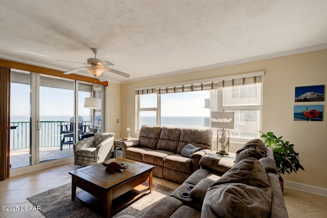 tiled living room featuring a water view, ceiling fan, ornamental molding, and a textured ceiling