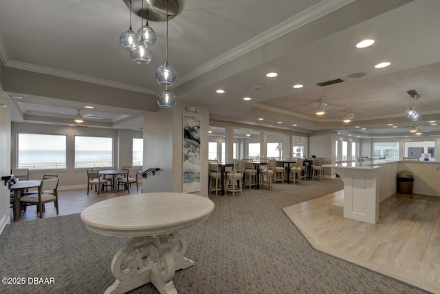 dining room featuring crown molding, a tray ceiling, plenty of natural light, and ceiling fan